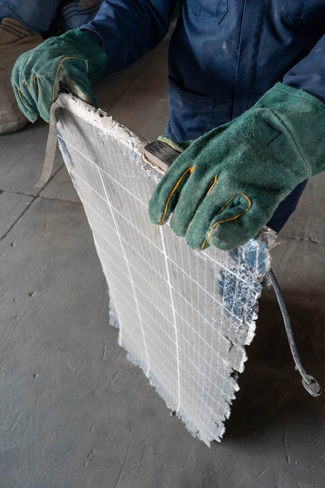 Technician handling a decommissioned solar module ahead of deframing at an EWaste Africa facility